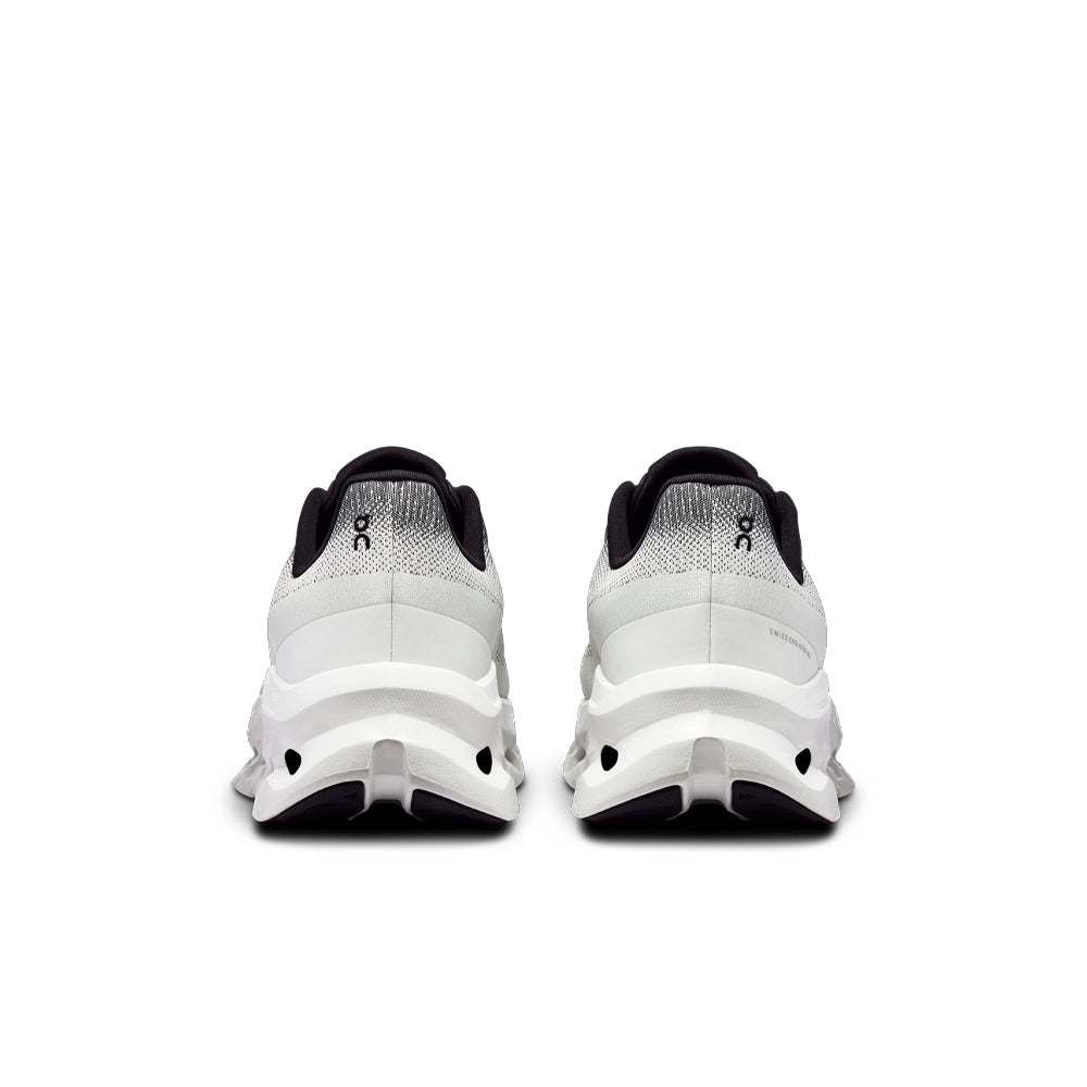 Rear view of On Cloudtilt Black Ivory sneakers, showing heel logos, black collars and sculpted ivory soles.