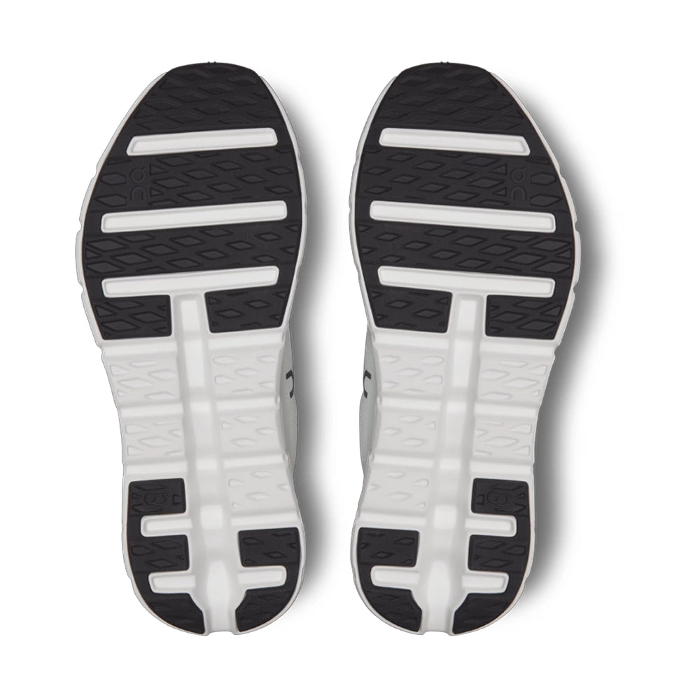 Outsoles of On Cloudtilt Black Ivory sneakers, showing black tread sections and ivory flex grooves.