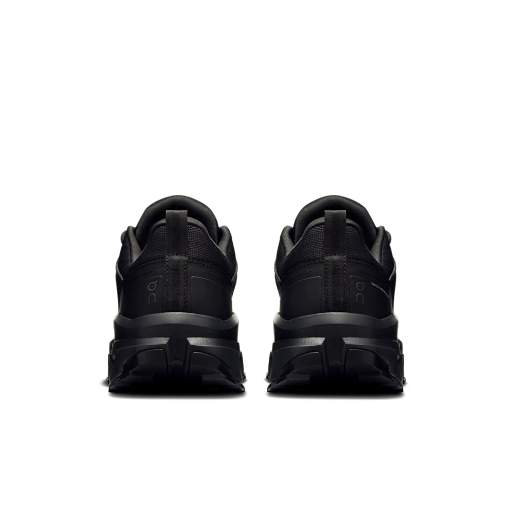 Rear view of black On Cloudrock Low Waterproof shoes showing heel pull tabs and wide soles.