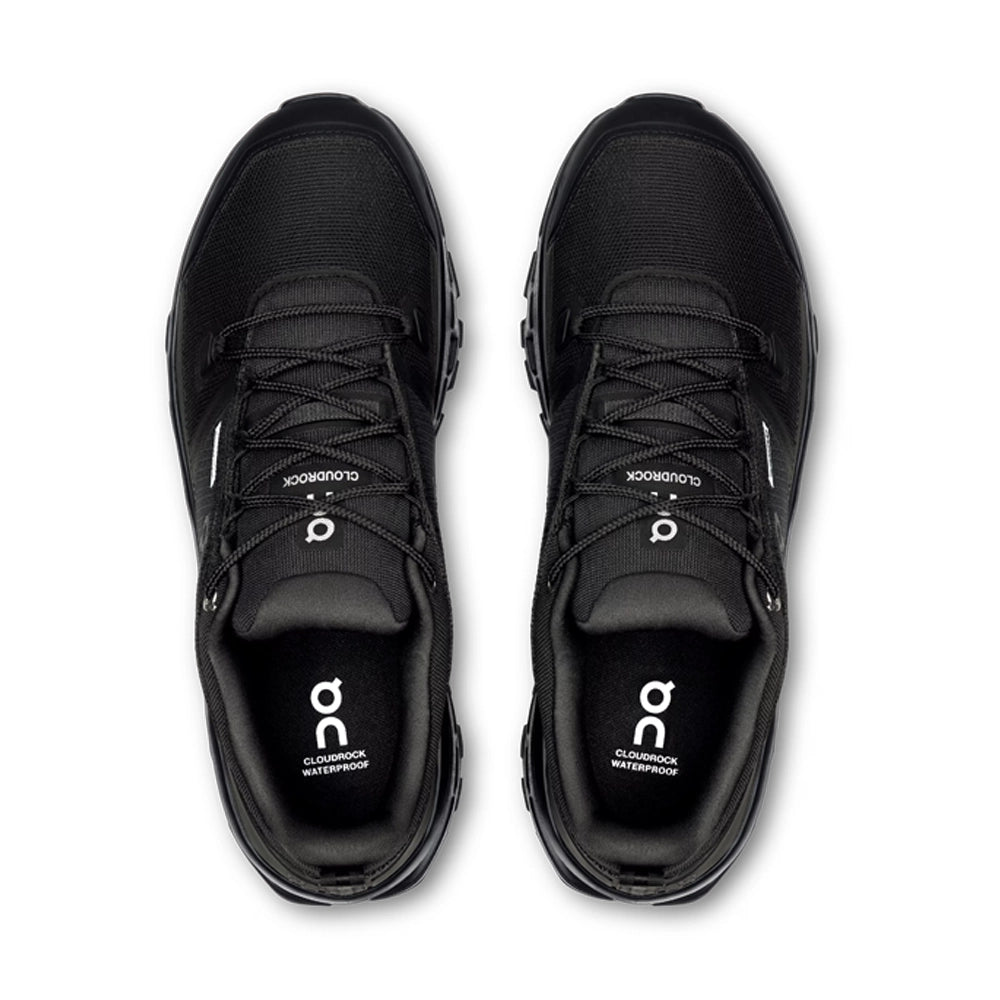 Top view of black On Cloudrock Low Waterproof shoes showing the laces, padded collars and branded insoles.