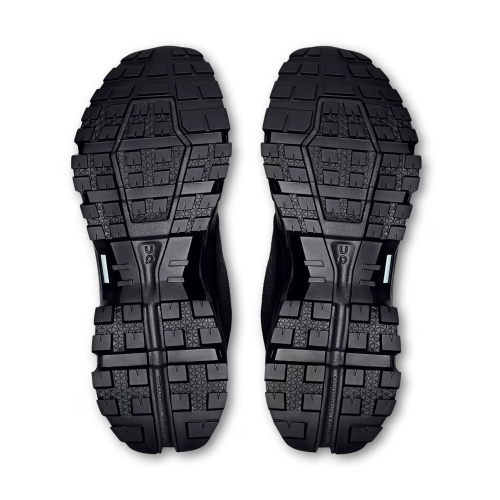 Bottom view of black On Cloudrock Low Waterproof shoes showing the deep, segmented tread pattern.