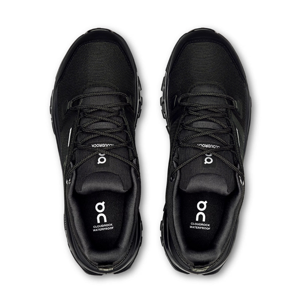Top view of the black On Cloudrock Low Waterproof shoes, showing the laces, padded tongues and branded insoles.