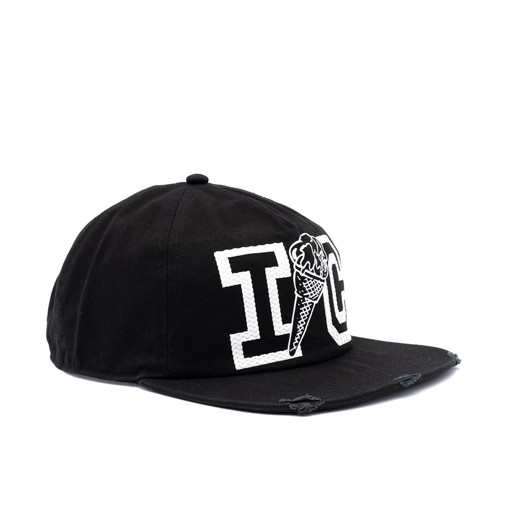A black flat-brim baseball cap with distressed details on the brim, featuring a white embroidered 'IC' monogram with an ice cream cone graphic on the front, set against a plain white background.