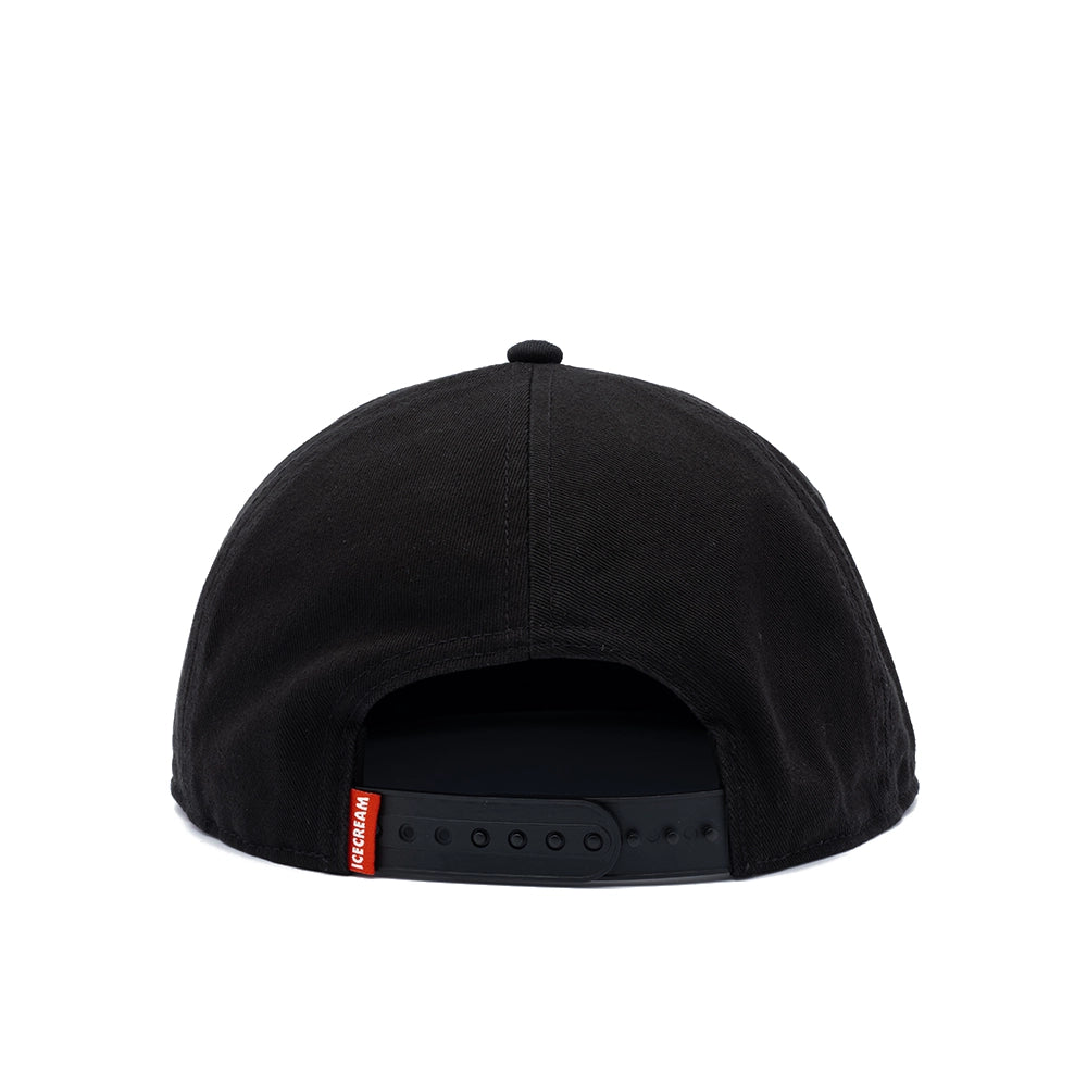 Black snapback cap shown from the back, featuring a black fabric crown, black visor, and a small red brand tag on the side.