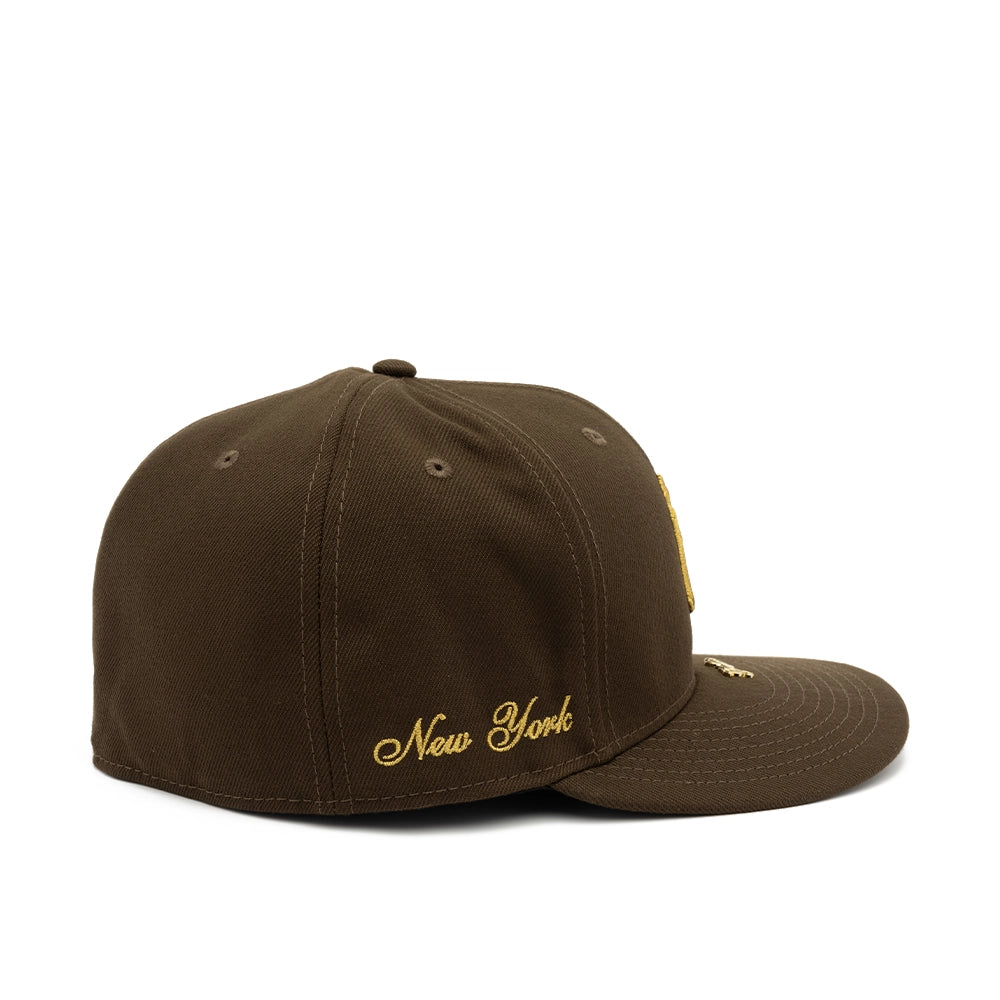 Side view of walnut brown Yankees 59FIFTY fitted cap with gold New York script embroidery.