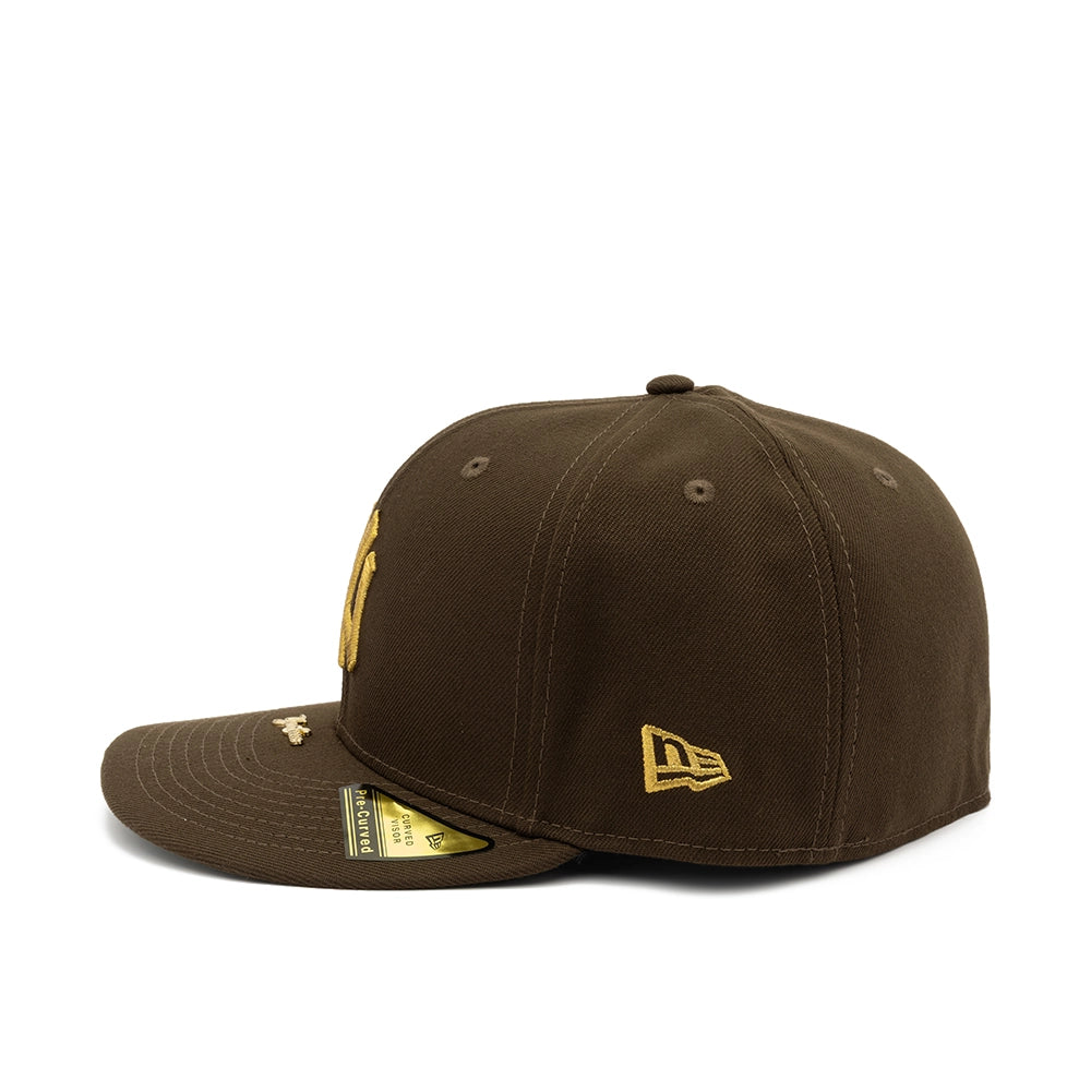 Side view of walnut brown Yankees 59FIFTY fitted cap with gold New Era flag embroidery.