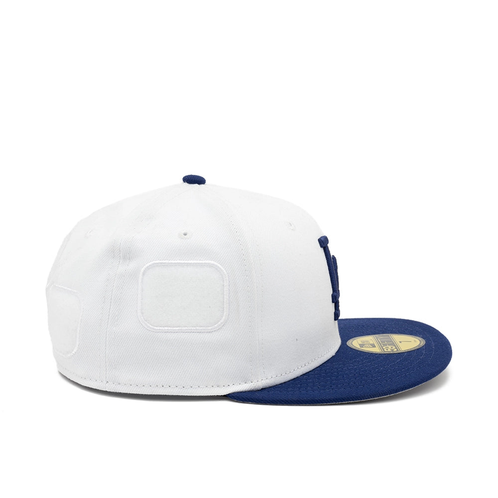 Side view of the white Dodgers 59FIFTY cap with empty white patch panels and a flat navy brim.