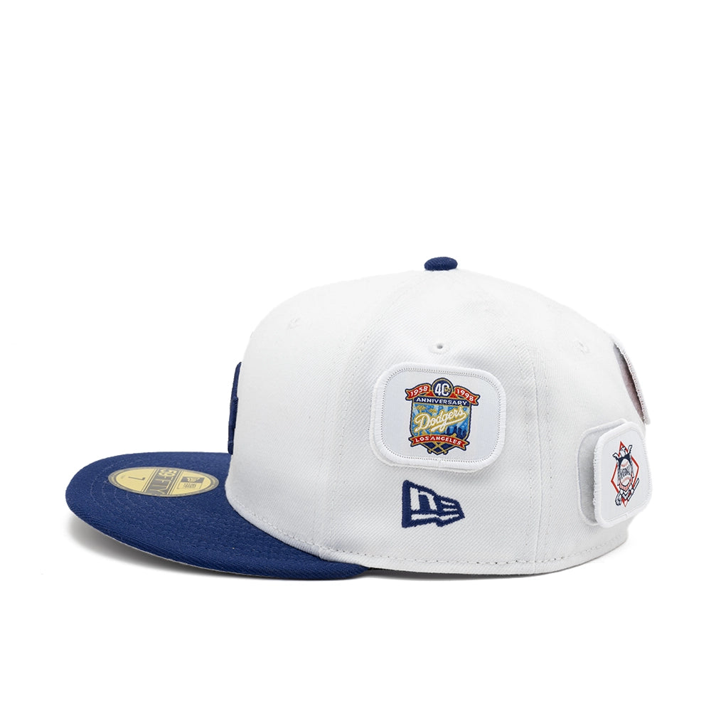 Side view of the white Dodgers cap with a 40th anniversary patch, navy New Era flag, and navy brim.