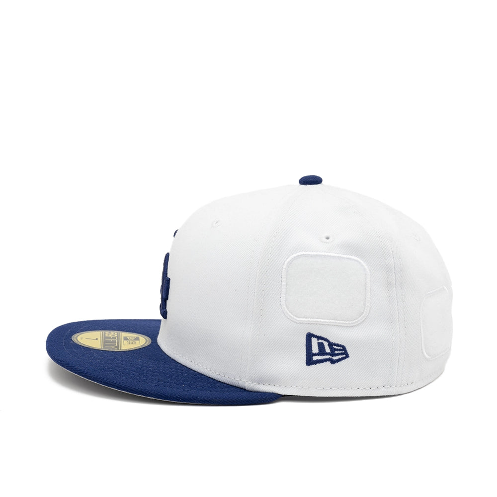 Side view of the white Dodgers fitted cap with an empty white patch panel above the navy New Era flag.