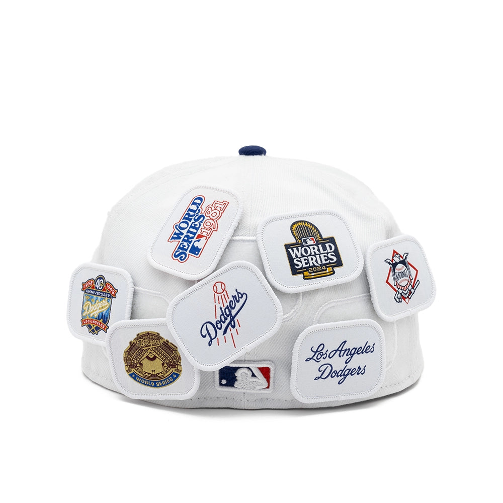 Back view of the white Dodgers fitted cap displaying assorted Dodgers anniversary and World Series patches.