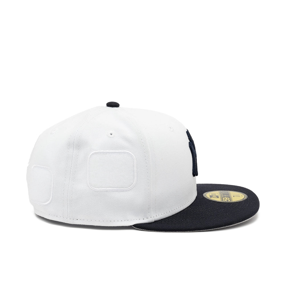 Side view of the white Yankees 59FIFTY fitted cap showing empty patch panels and a flat navy brim.