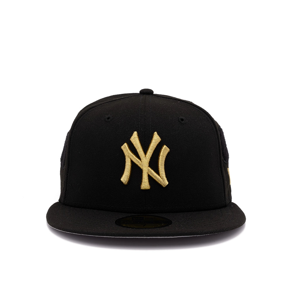 Front view of black New York Yankees 59FIFTY fitted cap with gold NY logo on white background