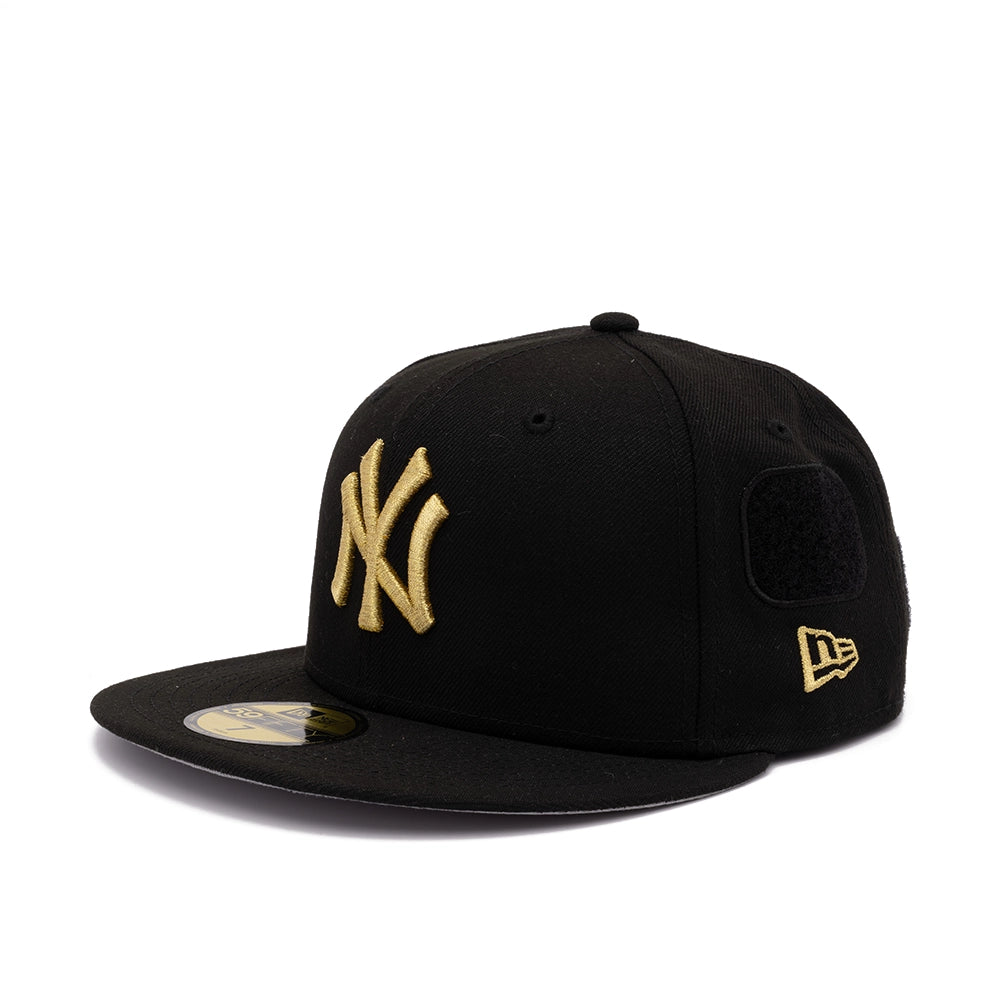 Side view of black Yankees 59FIFTY fitted cap with gold NY logo, black patch, and gold New Era flag