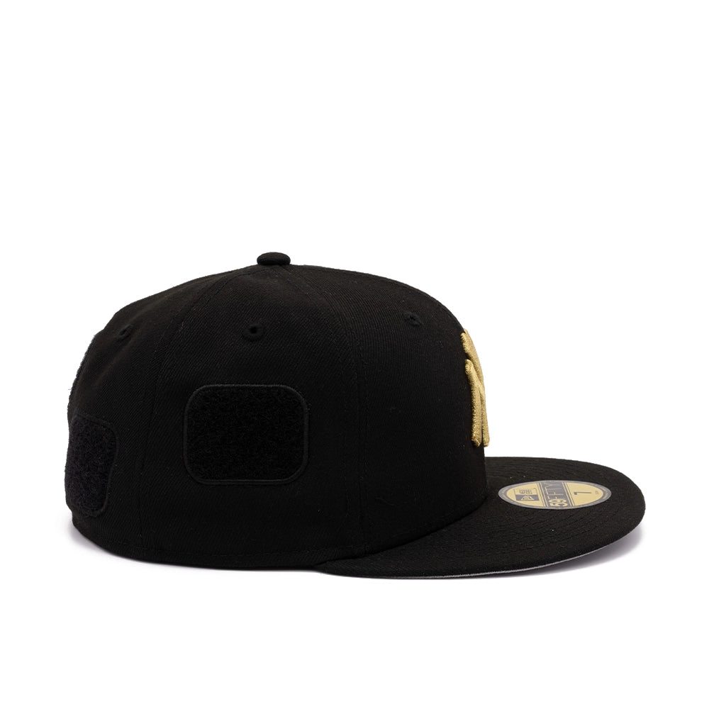 Side view of black Yankees 59FIFTY cap showing blank black patch, gold NY logo, and brim sticker