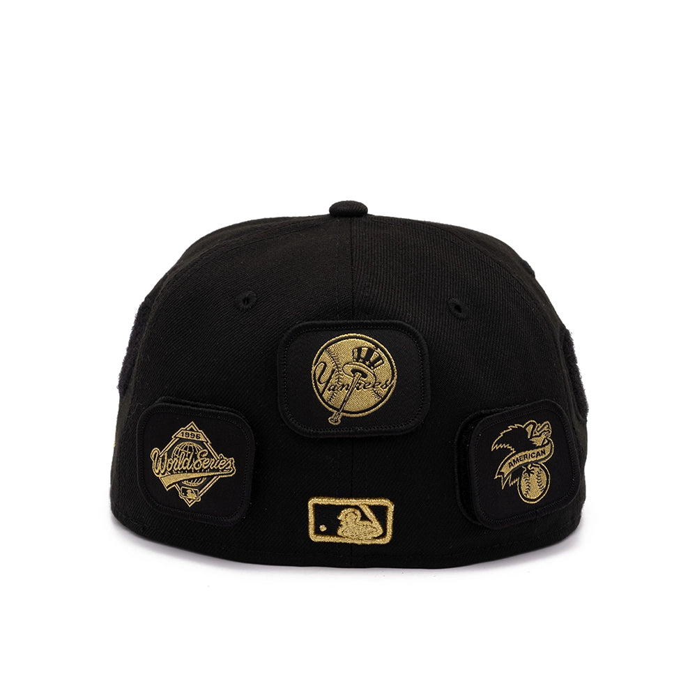 Back view of black Yankees 59FIFTY cap with gold Yankees, 1996 World Series, and American League patches