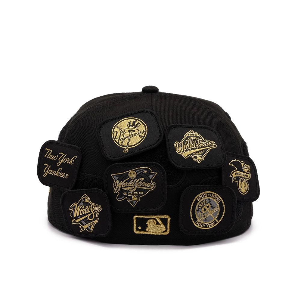 Crown of black Yankees 59FIFTY cap covered with gold commemorative patches including World Series and MLB logos