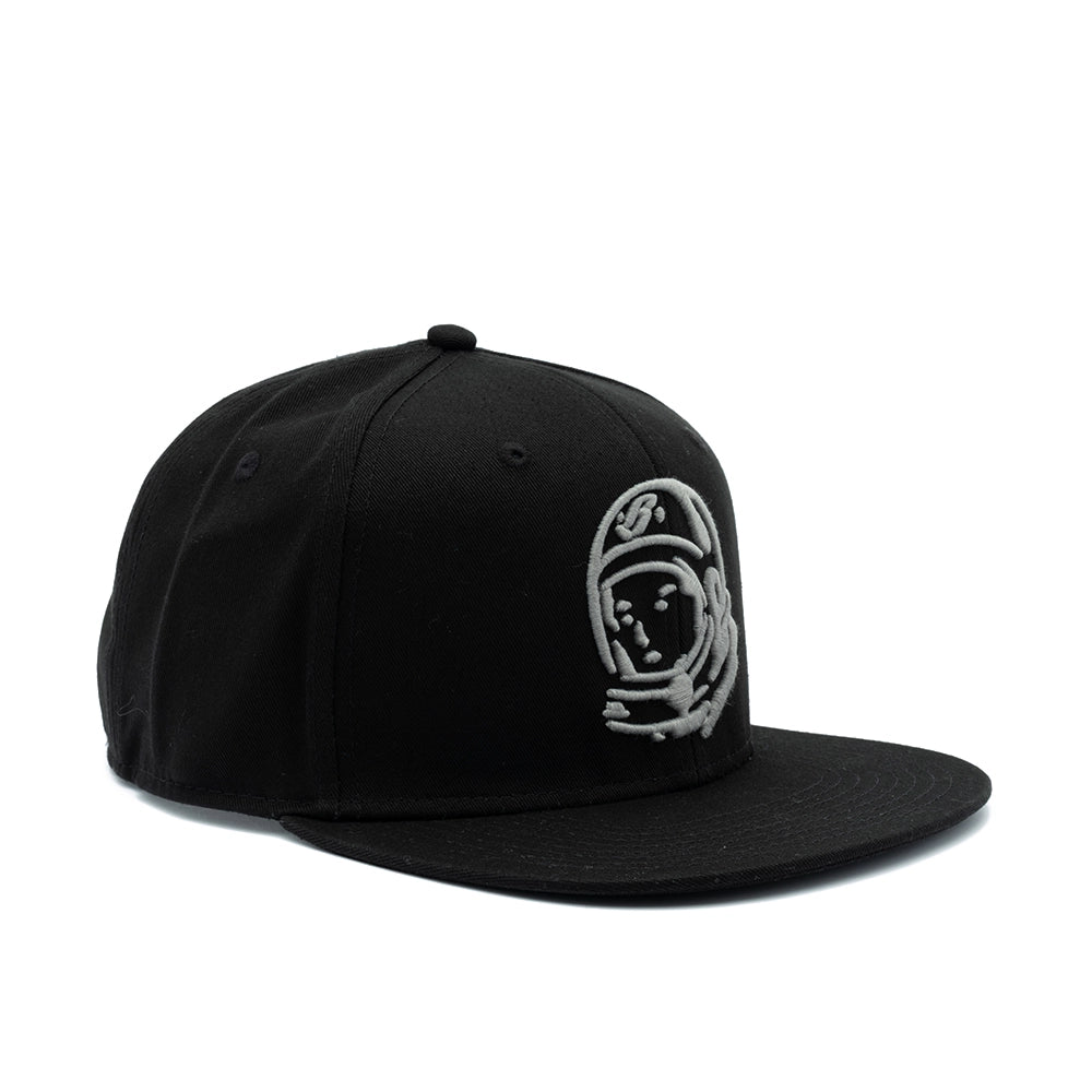 A black flat-brim snapback cap featuring a silver embroidered astronaut graphic on the front right panel, set against a plain white background.