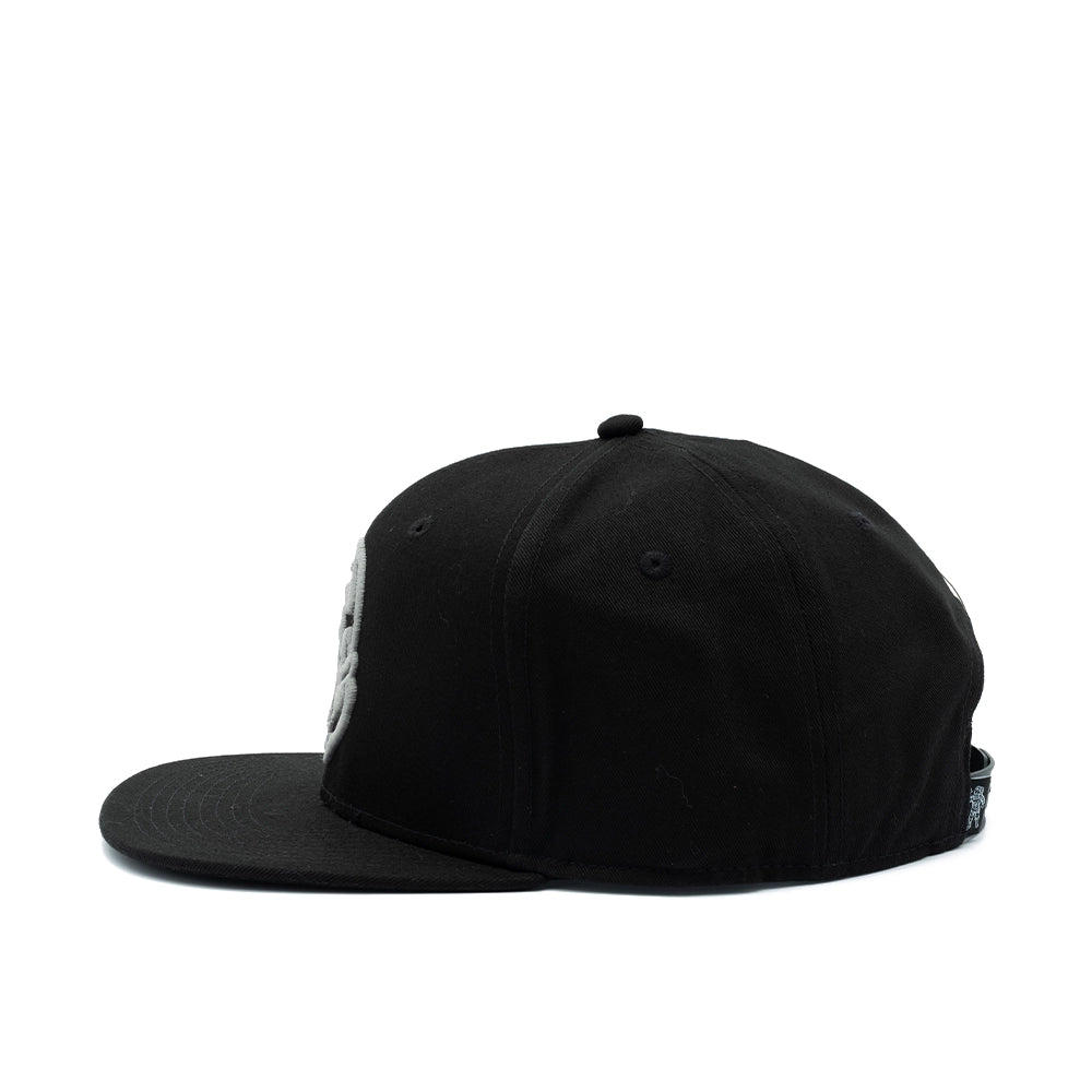 A black flat-brim snapback cap shown from a side profile view against a plain white background.