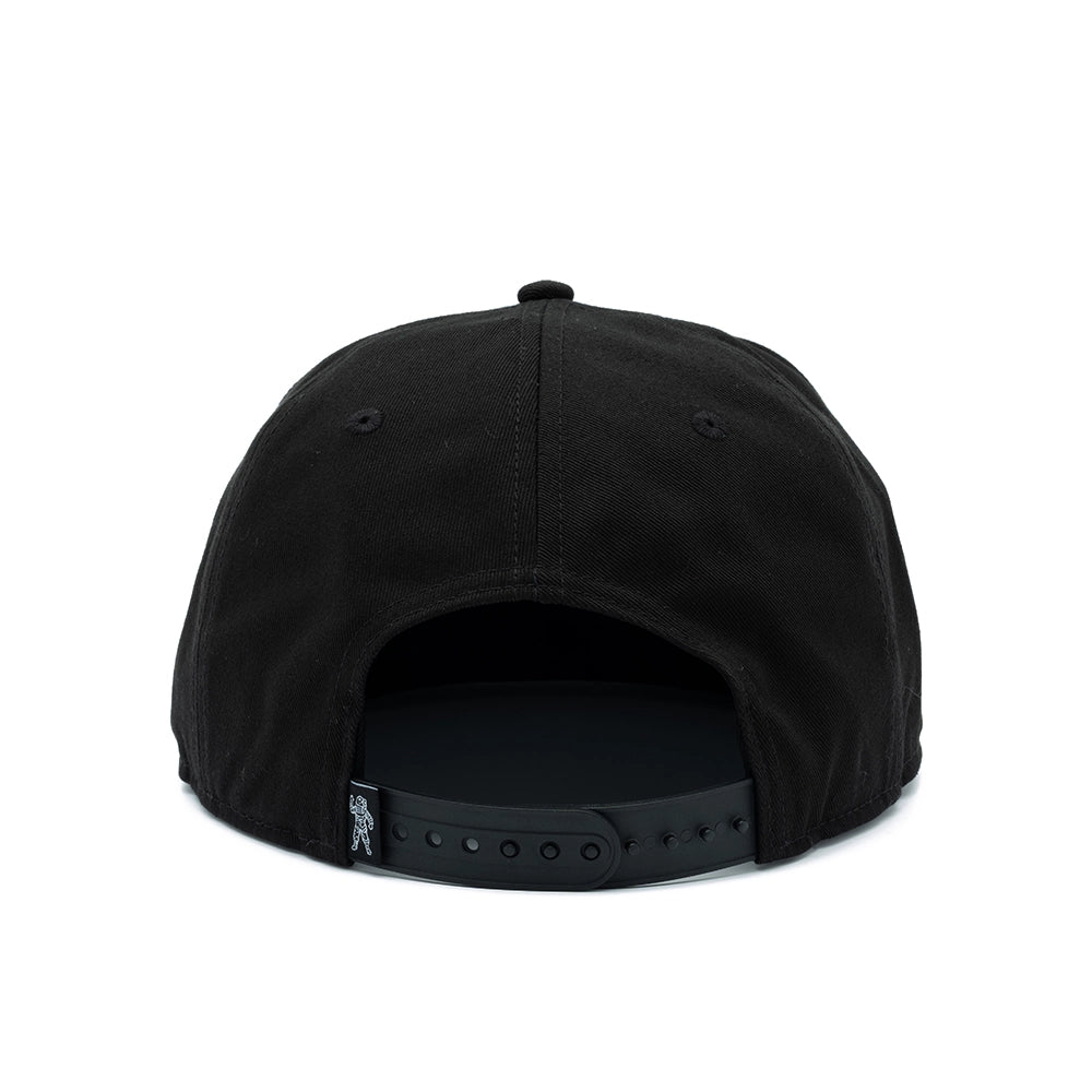 Black snapback cap shown from the back, featuring a structured fabric crown, button top, and adjustable black plastic strap with a small silver logo tag on the side, set against a plain white background.