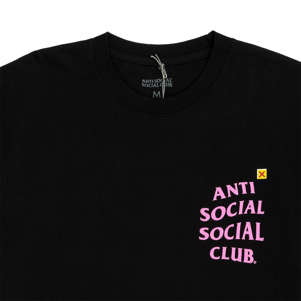 A close-up of a black crewneck t-shirt featuring the brand name 'ANTI SOCIAL SOCIAL CLUB' printed in pink on the left chest, with a small yellow X logo above it.