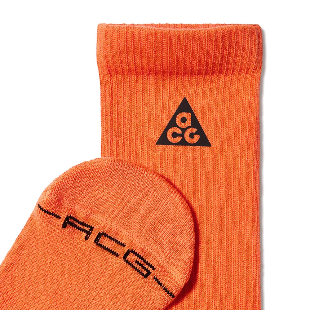 Close-up of Safety Orange Nike ACG socks showing the ribbed cuff, black ACG logo and toe lettering.
