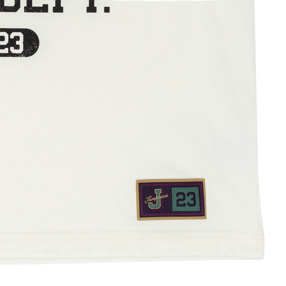 Close-up of the Jumpman patch with the number 23 near the hem of the Sail Jordan T-shirt.