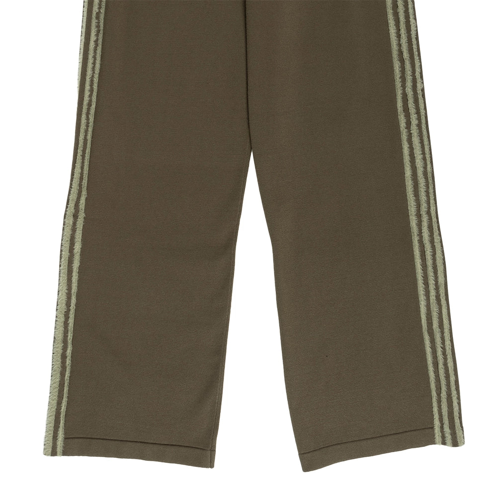 Close-up of the wide-leg hems and textured side stripes on adidas Knit Firebird track pants in Branch Silver Pebble.