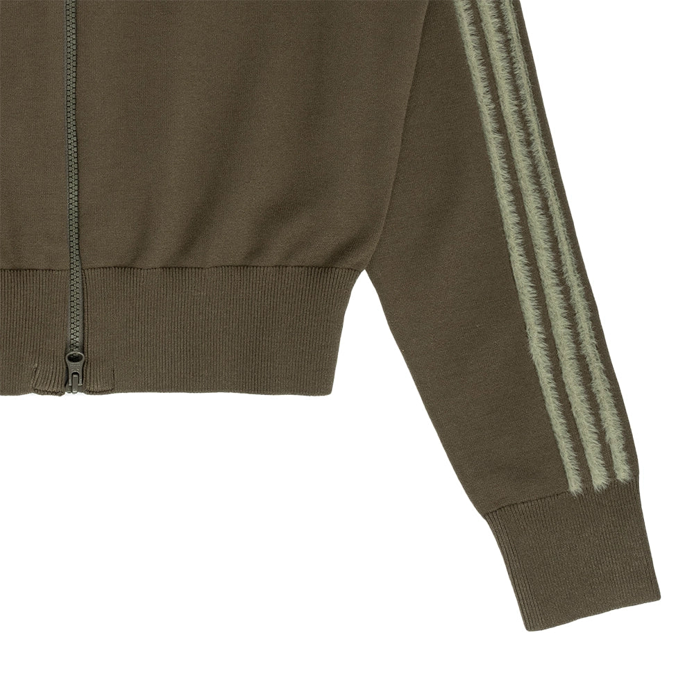 Close-up of adidas Firebird track top showing Silver Pebble sleeve stripes, ribbed cuff and hem.