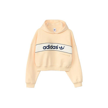 Front view of adidas women's adiSignature NY hoodie in Warm Vanilla with navy chest branding and ribbed cuffs.