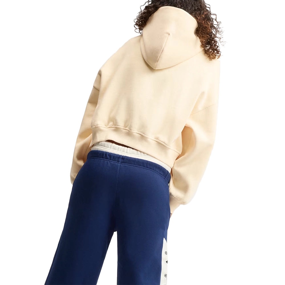 Model wearing the adidas women's adiSignature NY hoodie in Warm Vanilla, showing the hood and cropped fit from behind.