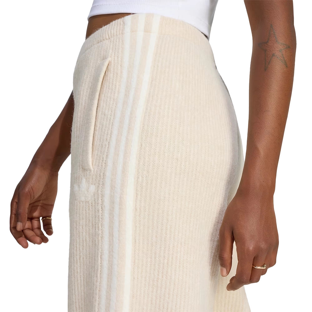 Side close-up of a model wearing adidas x Jennie Bliss cream knit pants with tonal 3-Stripes and a side pocket.