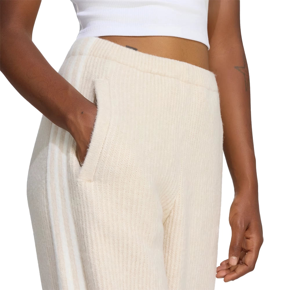 Front close-up of a model wearing adidas x Jennie Bliss cream knit pants with one hand in the side pocket.