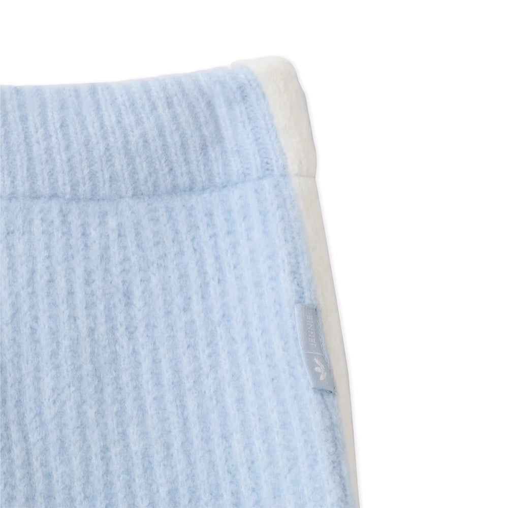 Close-up of the ribbed waistband and side label on adidas x Jennie Wonder Blue knit pants.