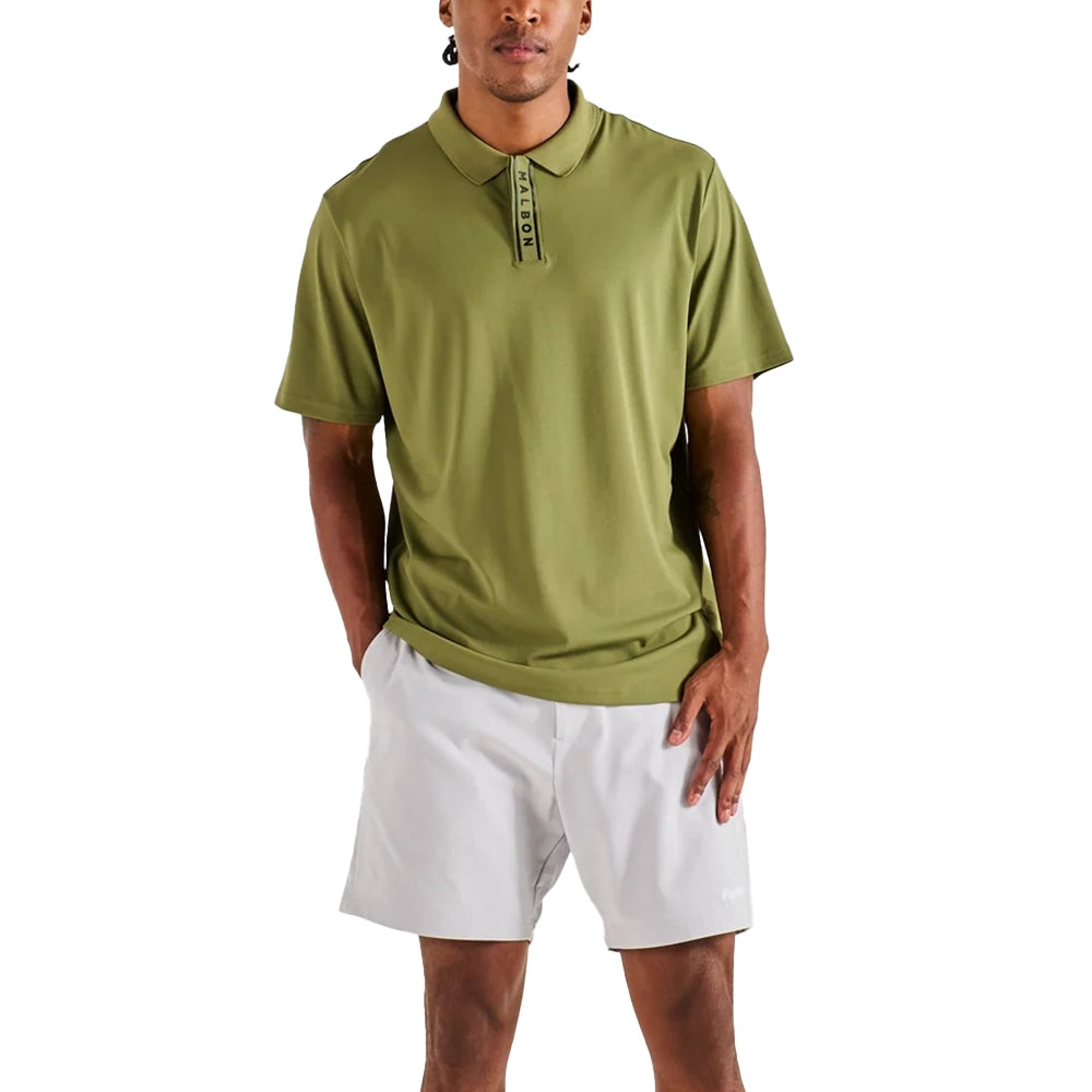 Model wearing the Malbon Block Placket Polo in military green with white shorts, viewed from the front.