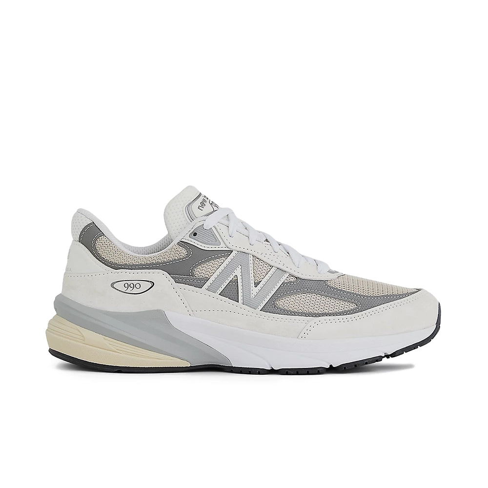 A New Balance sneaker in light gray, white, and beige, shown from a side profile view against a plain white background.